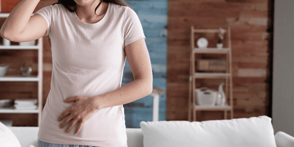 Woman holds her abdomen in apparent discomfort