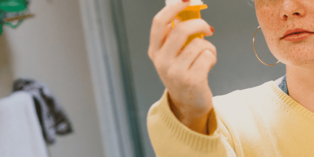 woman holds prescription pill bottle