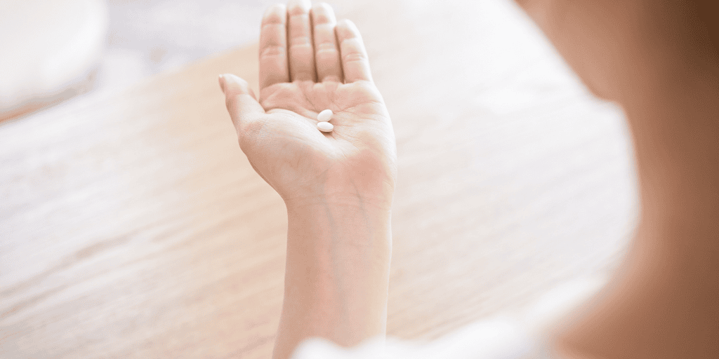 woman holding pills in her hand